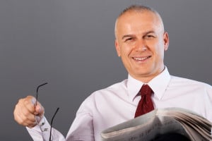 Middle aged businessman reading newspapers